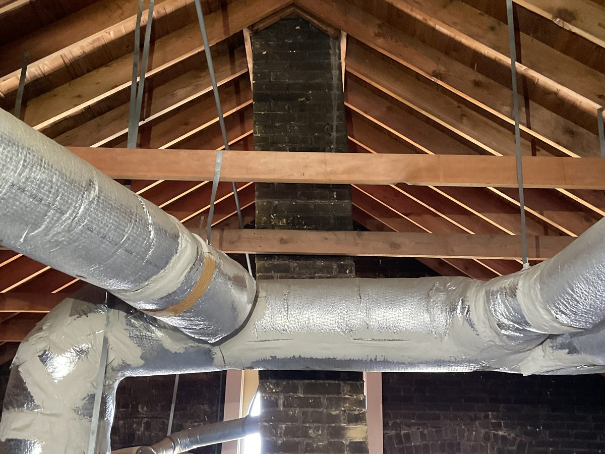 Attic framing and insulated HVAC ducts documented during an inspection