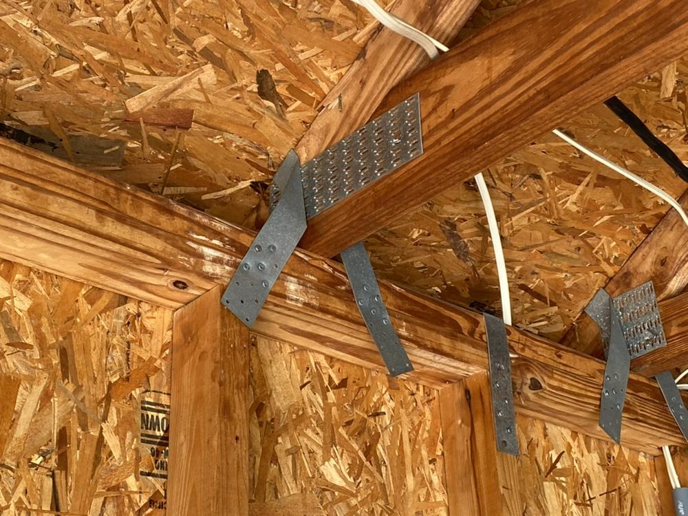 Close-up of a hurricane clip roof-to-wall connection during a wind mitigation inspection